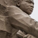 Cultural Movements - Granite statue of civil rights movement leader against overcast sky