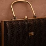 Vintage Trends - Vintage bag with golden handle placed on reflecting surface as accessory for garment