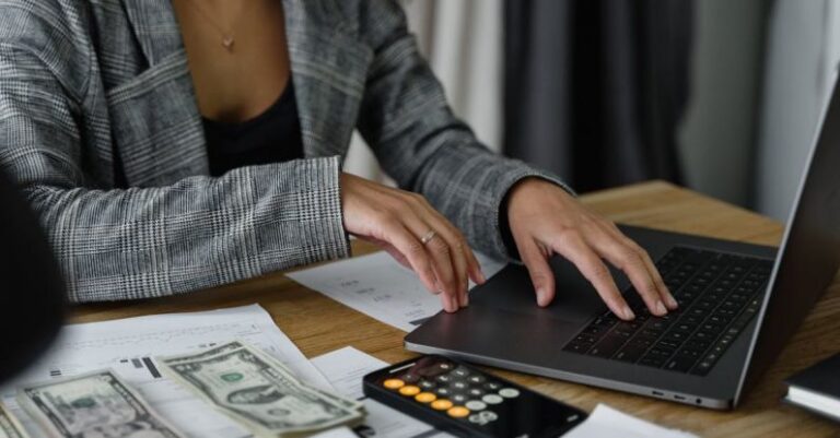 Budget Airlines - A Woman in Plaid Blazer Using Her Laptop