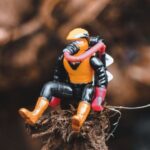 Superhero Movies - Small comic hero figurine placed on tree trunk