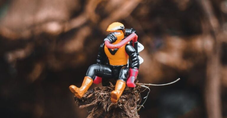 Superhero Movies - Small comic hero figurine placed on tree trunk