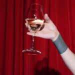 Theatrical Releases - Person on Stage Holding a Glass of Wine