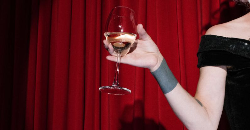 Theatrical Releases - Person on Stage Holding a Glass of Wine