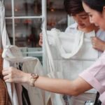 Sustainable Fashion - Trendy young Asian women choosing cotton bags in fashion boutique