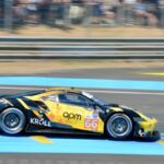 Action Sports - A yellow racing car on a track with people watching