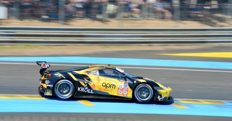 Action Sports - A yellow racing car on a track with people watching