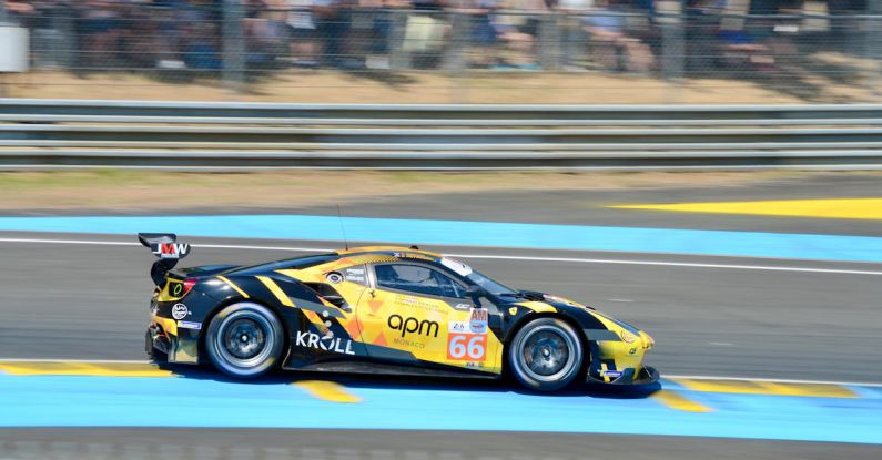 Action Sports - A yellow racing car on a track with people watching