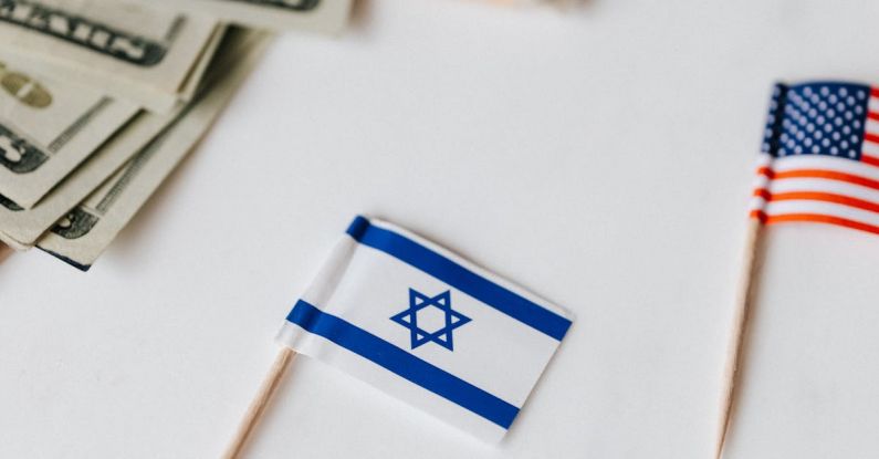Financial Independence - From above set of miniature toothpick flags of USA and Israel placed on white table with dollar banknotes